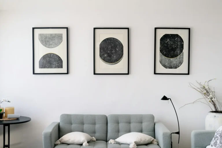 Quadros em preto e branco na parede acima do sofá