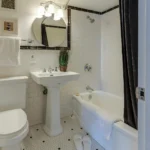Banheiro pequeno claro com pia de coluna e vaso sanitário branco