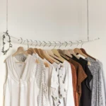 Roupas penduradas em cabides organizadas por cor