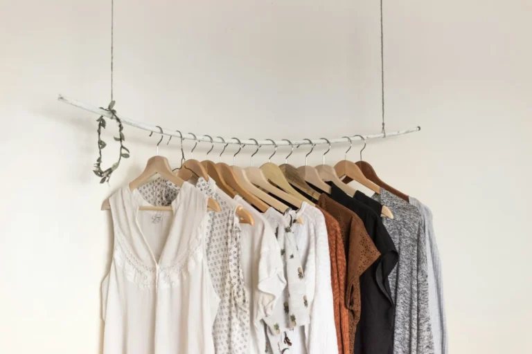 Roupas penduradas em cabides organizadas por cor